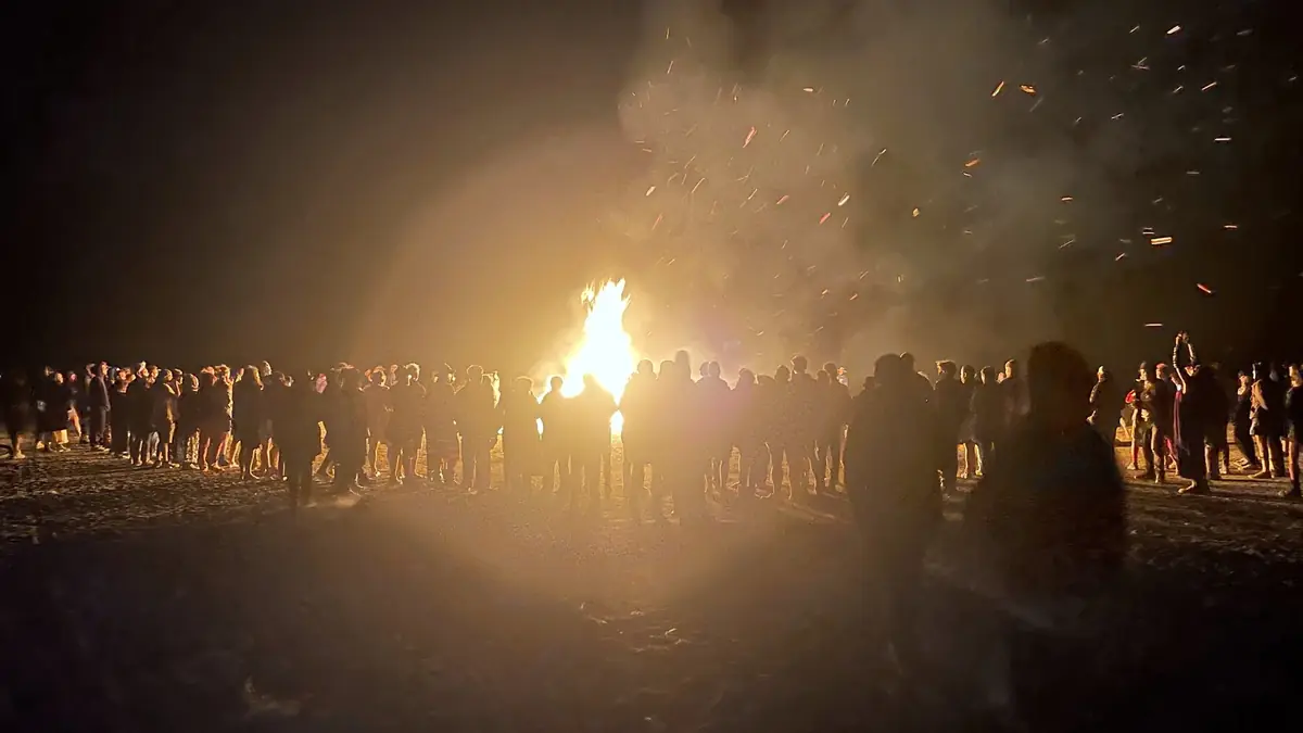 AfrikaBurn participants standing by a burning artwork